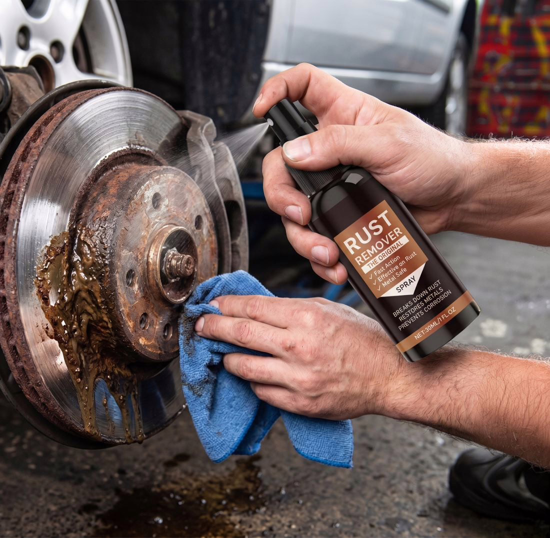 Twee handen maken een verroeste remschijf schoon met het middel en een doek